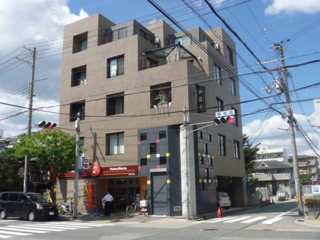 多くの窓を持つ建物、㈱アライズが運営する就労継続支援A型事業所の外観を示しています